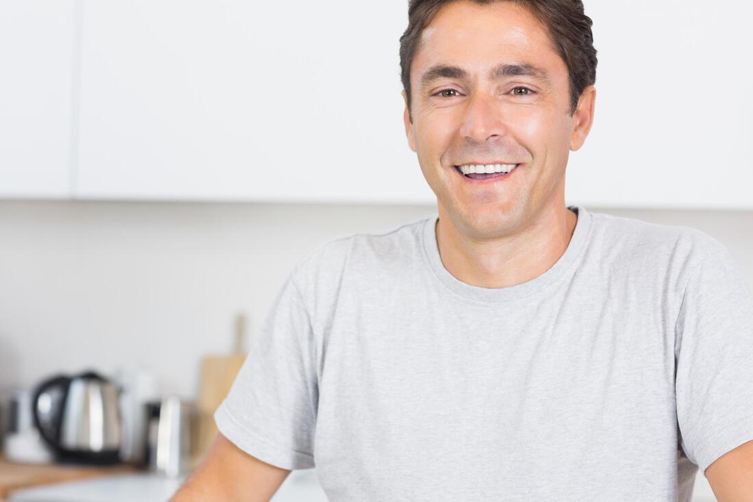 man smiling is wearing a gray shirt 