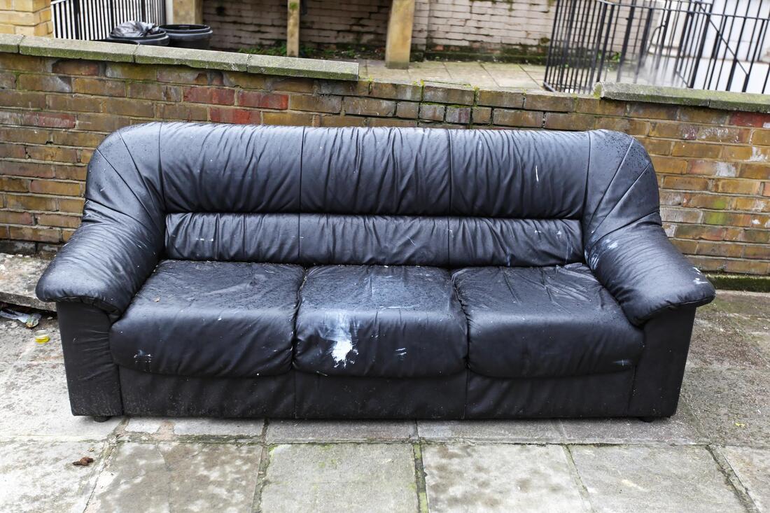 large damaged black sofa